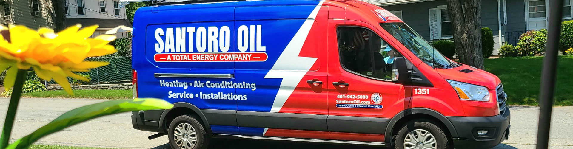 Santoro Oil service truck in front of a customer's home with a beautiful flower