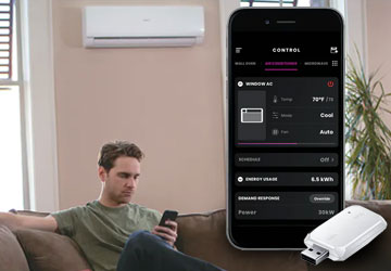 A man controls his ductless mini-split system air conditioner with his smartphone