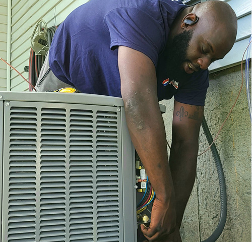 Santoro technician checking refrigerant connections on AC compressor