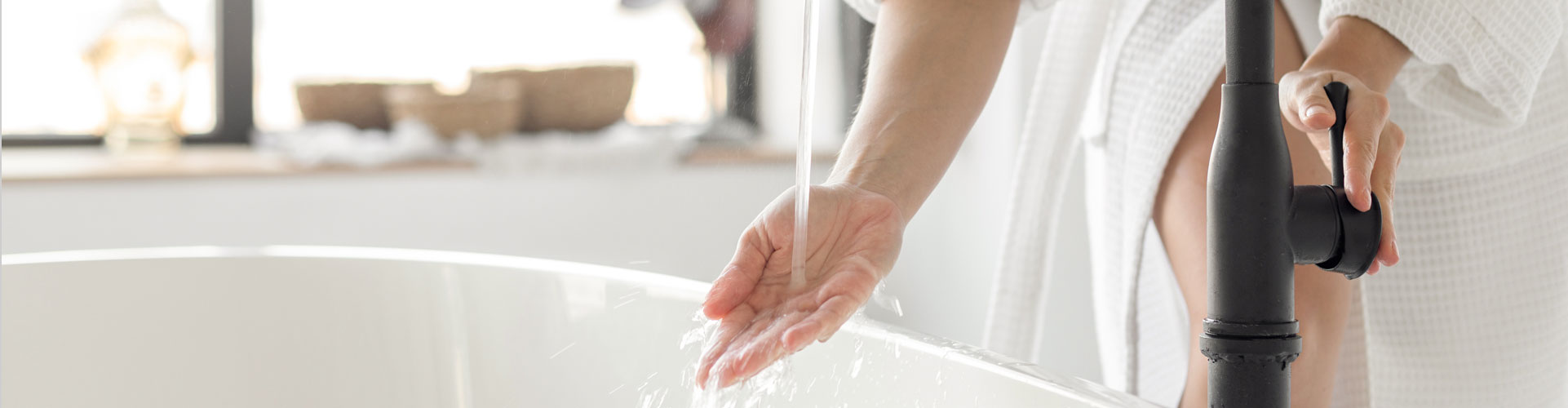 Woman drawing a bath with warm water supplied by a Santoro installed hot water heater